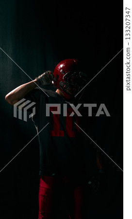 Football player adjusting helmet with strong emotional concentration Football player adjusting helmet with strong emotional concentration 133207347