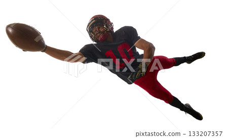 Football player diving forward with intense focus to catch the ball 133207357