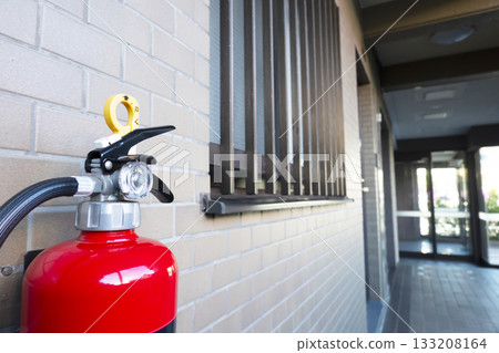 Fire extinguisher installed in the aisle of the apartment 133208164