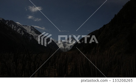 Majestic mountain landscape under moonlight with dark valley foreground Majestic mountain landscape under moonlight with dark valley foreground 133208265