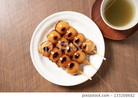 Mitarashi dango and tea on a white plate 133208682