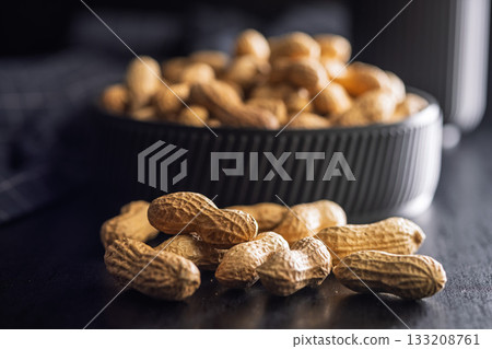 Peanuts in shell. Groundnuts on black table. 133208761