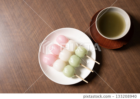 Three-colored dumplings and tea on a white plate 133208940