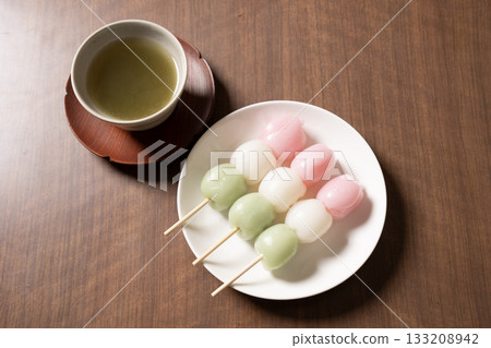 Three-colored dumplings and tea on a white plate 133208942
