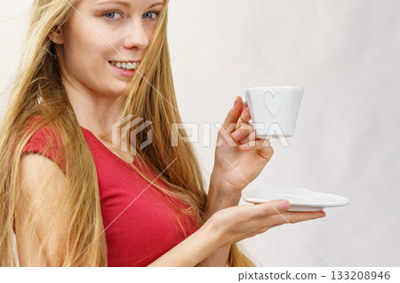 Blonde girl blowing hair holds coffee cup Blonde girl blowing hair holds coffee cup 133208946