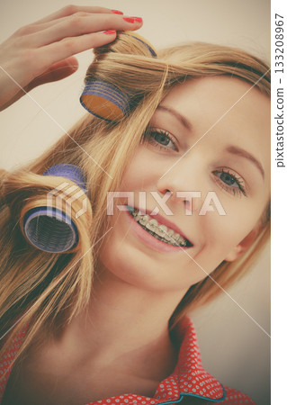 Woman curling her hair using rollers Woman curling her hair using rollers 133208967