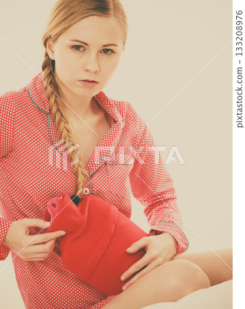 Woman feeling stomach cramps lying on bed 133208976