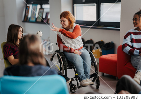 Teen students talking together in inclusive school setting. 133208998