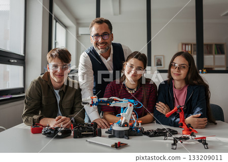 High school students working on robotics project with their teacher. 133209011