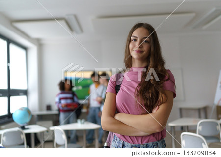 Confident teen student standing in modern classroom. 133209034