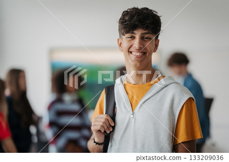 Confident teen student standing in modern classroom. 133209036