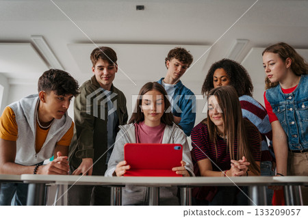 Teen students learning together with digital tablet in modern classroom. Teen students learning together with digital tablet in modern classroom. 133209057