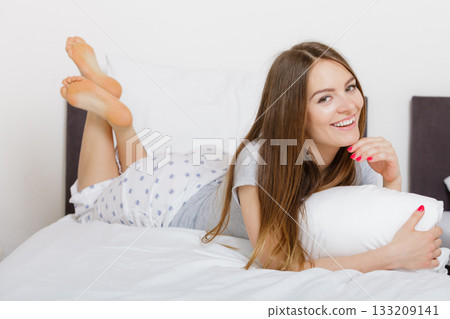 Cheerful girl rolling in bed. 133209141