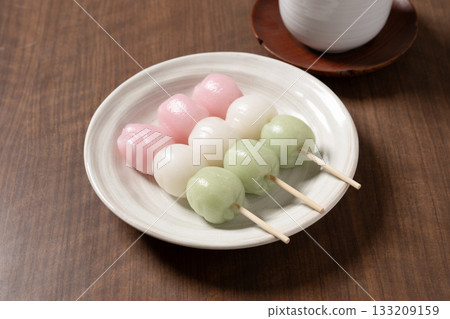 Three tricolored dumplings on a white plate 133209159