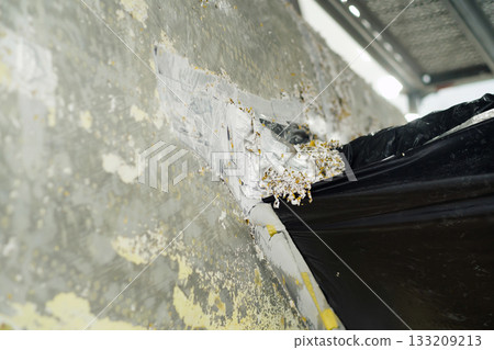 Renovation project reveals damaged wall in urban building, requiring repair and restoration efforts by workers during daylight hours Renovation project reveals damaged wall in urban building, requiring repair and restoration efforts by workers during daylight hours 133209213