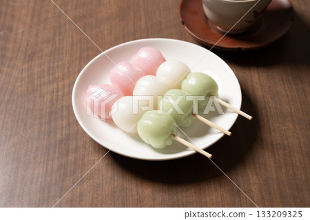 Three-colored dumplings and tea on a white plate 133209325