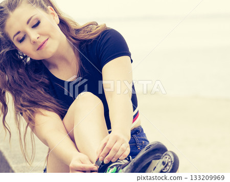 Woman putting roller skates on 133209969