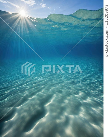 A peaceful underwater view showcasing the delicate ripples on a sandy seafloor, bathed in the soft glow of sunlight through clear blue ocean water. A peaceful underwater view showcasing the delicate ripples on a sandy seafloor, bathed in the soft glow of sunlight through clear blue ocean water. 133209972