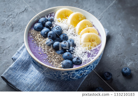 A smoothie bowl topped with chia seeds, sliced bananas, blueberries, and shredded coconut creating a colorful masterpiece. A smoothie bowl topped with chia seeds, sliced bananas, blueberries, and shredded coconut creating a colorful masterpiece. 133210183