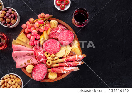 Italian Antipasti. Charcuterie platter with cheese and other snacks, with wine 133210190