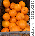 Box with ripe fresh organic tangerines on the shelf of a fruit supermarket are displayed for sale. Close-up 133210269