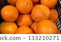 Ripe fresh organic oranges in box on the shelf of a fruit supermarket are displayed for sale. Close-up 133210271