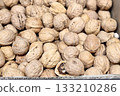 Large whole walnuts in large quantities in a basket on the market for sale. Healthy eating. Close-up. 133210286