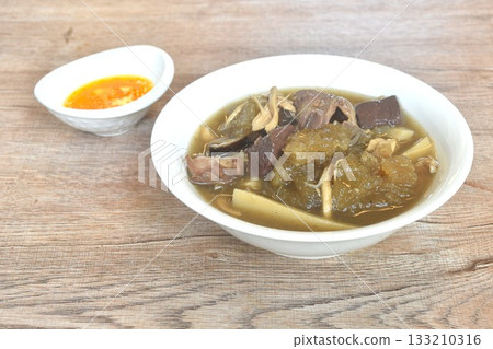 braised fish maw with bamboo shoot and pork blood with chicken organ in red gravy soup on bowl 133210316