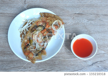 crispy fried egg and flour stuffed seafood with bean sprout on plate dipping chili sauce crispy fried egg and flour stuffed seafood with bean sprout on plate dipping chili sauce 133210318