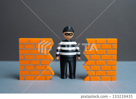 A criminal finds a hole in the wall. A breach in security. The threat of data theft and cybersecurity. System vulnerability and unauthorized access. Hacking risks, corporate espionage 133210435