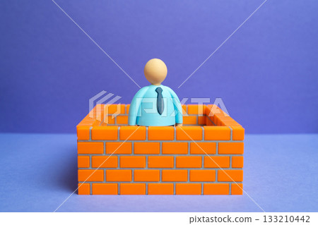An office worker is surrounded by walls. A comfort zone and self-enclosed barriers. Tolerating infringement and avoiding conflict. Lack of emancipation. Isolation, and limited potential. An office worker is surrounded by walls. A comfort zone and self-enclosed barriers. Tolerating infringement and avoiding conflict. Lack of emancipation. Isolation, and limited potential. 133210442