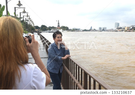 daughter used camera photo mother at landscape of Cho phraya river in Thailand on rainy day 133210637