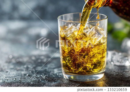 A close-up of Lebanese 'arak' (anise-flavored spirit) being poured over ice, creating a cloudy swirl, a classic beverage ritual. A close-up of Lebanese 'arak' (anise-flavored spirit) being poured over ice, creating a cloudy swirl, a classic beverage ritual. 133210659