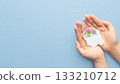 World autism awareness day concept. Hands holding human head shape with colorful jigsaw puzzle brain on blue background. Creative idea for Autism Spectrum Disorder (ASD). 133210712