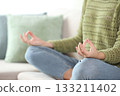 Close up of a casual woman in green doing yoga at home 133211402