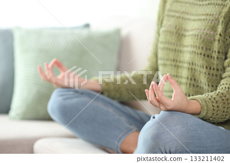 Close up of a casual woman in green doing yoga at home 133211402