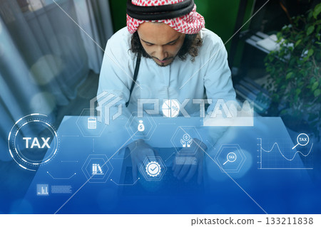 Man working on tax documentation with digital graphics in a modern office setting Man working on tax documentation with digital graphics in a modern office setting 133211838