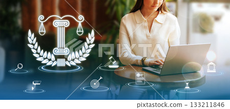 Legal professional working on a laptop with symbols of justice in a modern office setting Legal professional working on a laptop with symbols of justice in a modern office setting 133211846