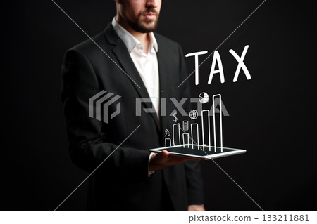 Businessman presenting tax data with graphs and charts on a digital tablet 133211881