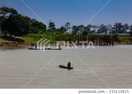 Man sitting at a traditional wooden canoe at the Sinu River in Lorica, Colombia Man sitting at a traditional wooden canoe at the Sinu River in Lorica, Colombia 133212615