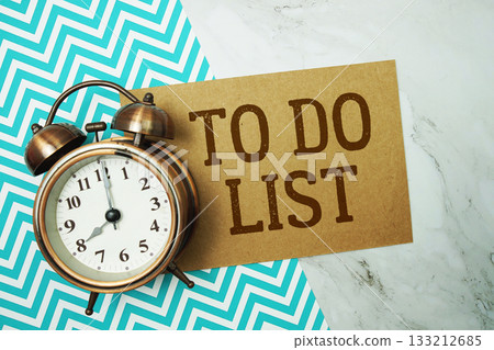 To Do List text written on paper card with alarm clock on marble background 133212685