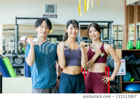 在健身房進行肌肉訓練的男女 在健身房進行肌肉訓練的男女 133213867