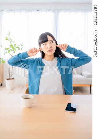 A young woman who plugs an ear A young woman who plugs an ear 133213899