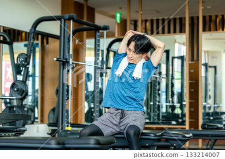 一名男子正在健身房做熱身運動。 一名男子正在健身房做熱身運動。 133214007