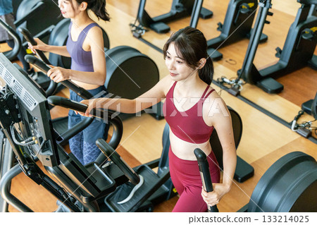 Men and women using cross trainers Men and women using cross trainers 133214025