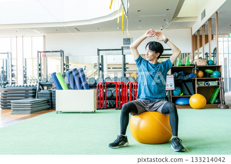 A man riding a balance ball 133214042