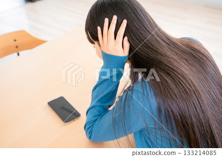 A young woman who plugs an ear 133214085
