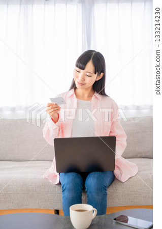 Young woman shopping online on a computer Young woman shopping online on a computer 133214230