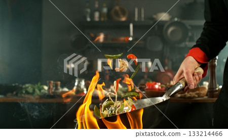 Freeze Motion of Flying Asian Meal with Vegetable and Prawns into Wok Pan 133214466