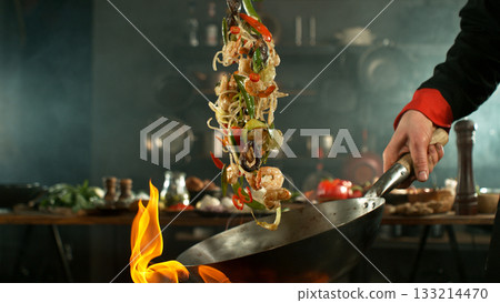 Freeze Motion of Flying Asian Meal with Vegetable and Prawns into Wok Pan 133214470